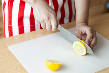 Hand using knife for cut and slide lemon