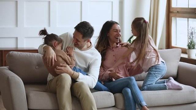 Funny happy family having fun tickling on couch, slow motion