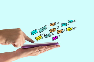Close-up of a woman's hand using a smartphone to send an email.