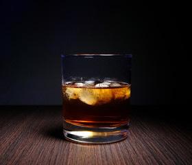 glass with whiskey and ice cubes