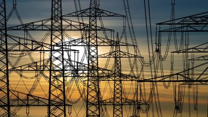 High voltage Power Lines with Pylons and Cable, Time Lapse at Sunset with Colorful Clouds and Sun - Powered by Adobe