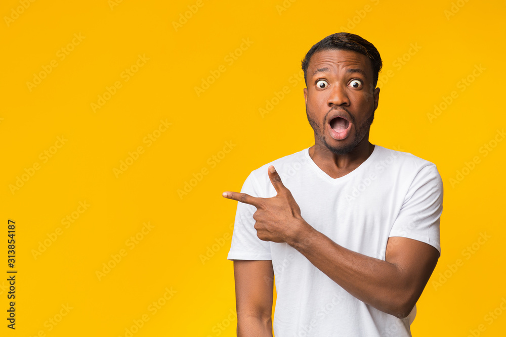 Canvas Prints Surprised Black Man Pointing Finger Aside Standing In Studio