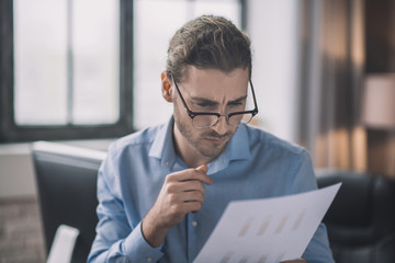 Young bearded man in blue shirt looking concentrated