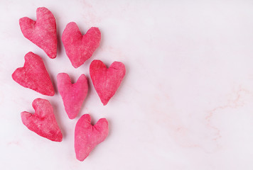 Hand made fabric hearts craft top view on pink background with copy space
