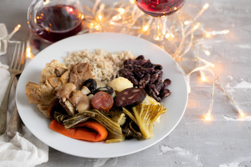 typical portuguese dish boiled meat, smoked sausages, vegetables and rice on white plate