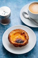 typical portuguese egg tart pastel de nata on blue paper background