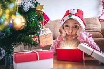 Happy a little girl with a glowing Christmas gift box, Christmas and New Year concept.
