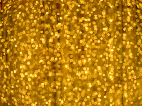Abstract blurred background of defocused blur bokeh wallpaper. Festive gold lights bokeh.