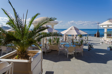 An empty cafe on the seaside promenade of the resort town in the early morning.