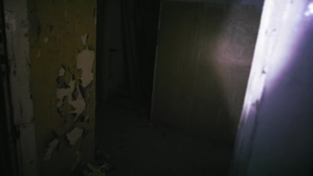 Searching a haunted house with a flashlight in the dark, pov shot
