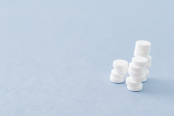 White pills on a blue background. Medical pharmacy concept