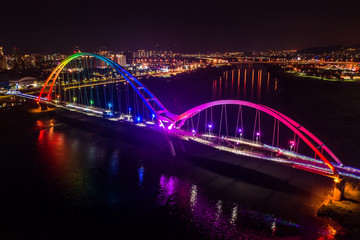Obraz na płótnie Canvas Crescent Bridge - landmark of New Taipei, Taiwan with beautiful illumination at night, photography in New Taipei, Taiwan.