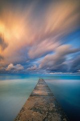 Fototapeta na wymiar Long exposure seascape fine art photograph of pier on a sunrise in Paphos, Cyprus 