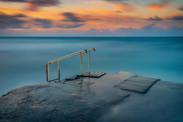 Long exposure seascape fine art photograph of pier on a sunrise in Paphos, Cyprus 