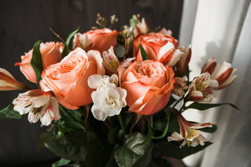  large luxurious bouquet of peony roses of coral color with white freesia in noir style on a dark background. dark romance