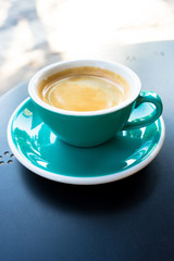 A cup of coffee on the table. A fresh morning coffee time in downtown street cafe.  