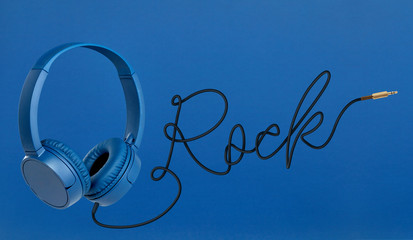 Headphones with rock cable on blue background