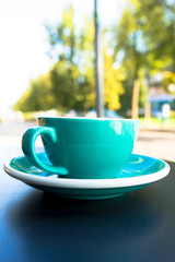 A cup of coffee on the table. A fresh morning coffee time in downtown street cafe.  