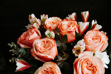 large luxurious bouquet of peony roses of coral color with white freesia in noir style on a dark background. dark romance