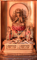Golden wooden statue depicting the bodhisattva Jundei depicted sit down on a red lotus in the Tendai Buddhism Gokokuin temple in the Ueno district of Tokyo.