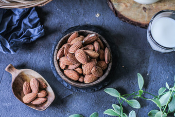 Photo of almond in wooden bowl on dark background. Top view of almond. Almond with wooden spoon or scoop. Almond concept. Images.