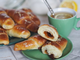 Ready-made toasted homemade bagels on a black baking sheet from the oven. Ready to eat. Sprinkled with sesame seeds. Home kitchen.