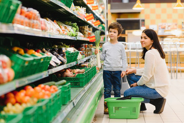 Mother and child shopping at farmer's market for fruits and vegetables