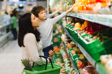 Mother and child shopping at farmer's market for fruits and vegetables