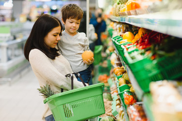 woman and child boy during family shopping with trolley at supermarket