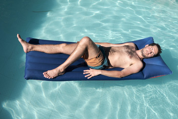 a handsome young men on swimwear resting in the swimming pool