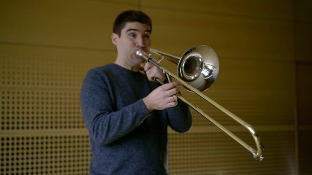 the Professor of the Conservatory plays the trombone, stops, takes a breath, and continues to play. average plan