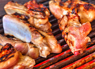 Grilling fresh meat on barbeque close up view