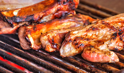 Grilling fresh meat on barbeque close up view
