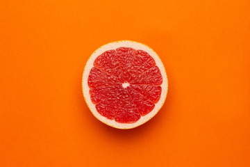 Grapefruit on an orange background, fruit flatlay, summer minimal compositon