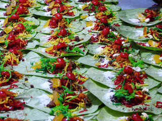 Banarasi paan or betel leaf garnished with betel nut and all indian colorful banarasi ingredients for sale