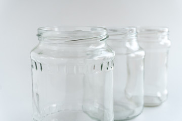 Empty glass jars at white background.