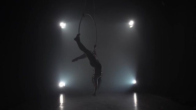Aerial acrobat in the ring. A young girl performs the acrobatic elements in the air ring. Slow motion. 007