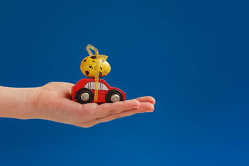 Child hands holding easter egg on car. Holiday concept