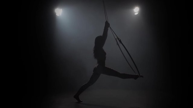Young girl performs the acrobatic elements in the air ring. Slow motion. 019