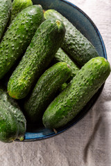 Fresh local cucumbers in bowl, top view healthy food