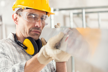 Builder sighting along a plank or tool