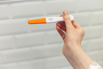 Rapid pregnancy test with positive result in woman's hand, close up view. Human chorionic gonadotropin test