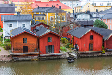 Fototapeta na wymiar Porvoo town, Finland. Old red wooden houses on the river coast on a cloudy day
