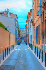 Narrow street with orange typical houses with bright blue sky - Aix en Provence, France