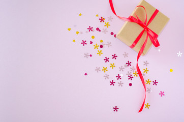 Gift box and white heart on a pink background. Valentine's day and romantic concept. Flat lay. Copy space.