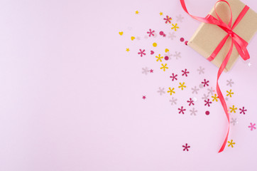 Gift box and glitters on a pink background. Valentine's day and romantic concept. Flat lay. Copy space.