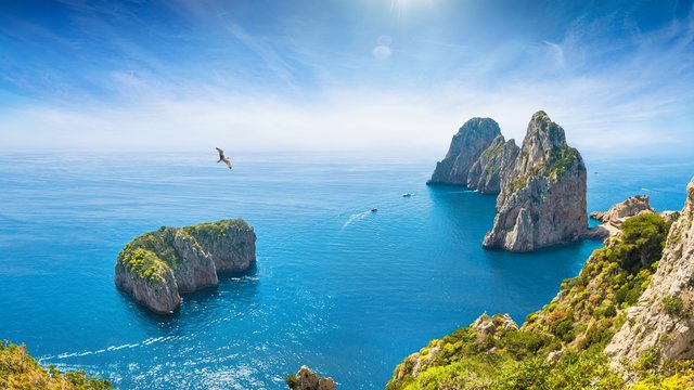 Famous Faraglioni Rocks near Capri Island, Italy. Beautiful paradise landscape with azure sea in summer sunny day.