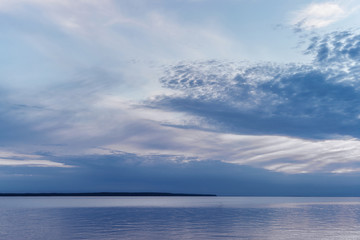 Fototapeta na wymiar Beautiful blue evening sky over the sea bay with a horizon line.