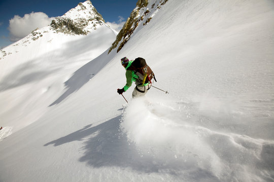 Woman skiing through backcountry powder on a hut trip in British Columbia, Canada.