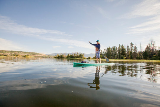 One woman paddle boarding on Lake Dillon in Summit County, Colorado in the early morning.